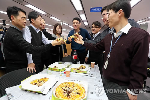 '문 대통령이 보낸 피자' (세종=연합뉴스) 김인철 기자 = 6일 오후 정부세종청사 기획재정부에서 직원들이 문재인 대통령이 2018예산안과 세제개편안 등으로 격무에 시달린 직원들에게 고마움의 표시로 보낸 피자를 먹고 있다.     yatoya@yna.co.kr