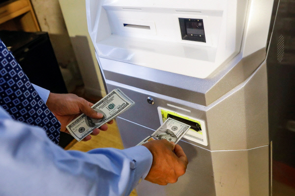 11월 27일, 미국 뉴욕시에 있는 비트코인 ATM에서 한 남성이 달러를 비트코인으로 바꾸고 있다.  / 로이터연합뉴스