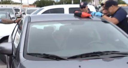 괌 현지 경찰이 한국인 판사 부부 차량 내 아이들을 구조하고 있다. [사진 KUAM 뉴스 보도 화면 캡처]