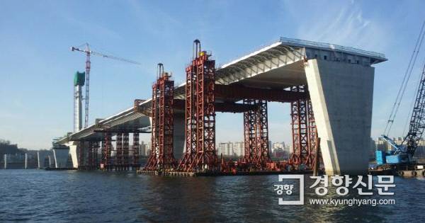 바지선으로 상판 블록을 들어올려 조립한다.