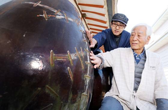 신평양조장 김용세씨와 그의 아들 김동교(뒤)가 양조장 창업 당시인 1933년부터 쓴 항아리를 보고 있다. 이 항아리는 50년전 깨진 것을 땜질해서 사용중이다. 양조장에는 창업 당시부터 사용중인 항아리가 40여개 남아있다. 프리랜서 김성태