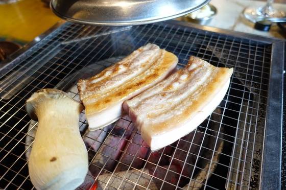 고기 토막 한쪽 면을 노릇하게 구워 뒤집었다.