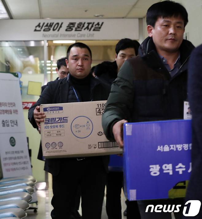 서울지방경찰청 광역수사대 수사관들과 질병관리본부 직원들이 19일 오후 신생아 4명이 사망한 서울 양천구 이대목동병원 신생아 중환자실에 대한 압수수색을 마친 뒤 압수품이 든 상자들 들고 나오고 있다. 2017.12.19/뉴스1 © News1 오대일 기자
