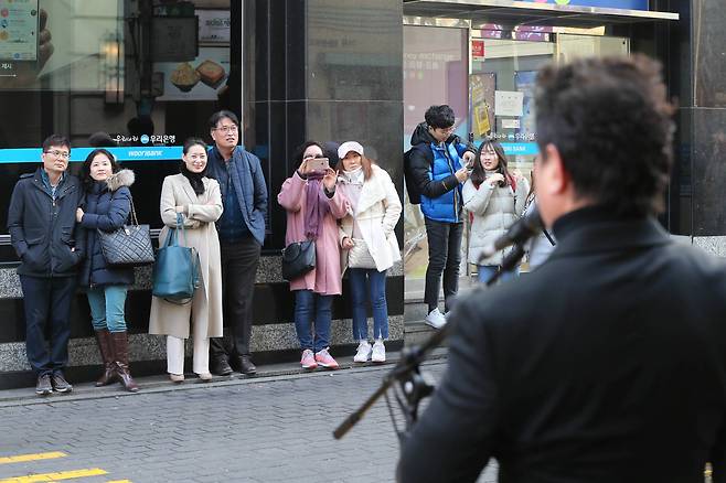 성악가인 노희섭 인씨엠예술단 단장이 길거리 성악 버스킹 1000회에 도전하고 있다. 서울 명동 우리은행 앞에서 사람들이 멈춰서서 노래를 듣고 있다. 신인섭 기자