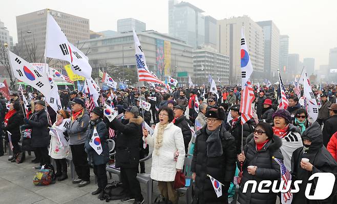 30일 서울 종로구 광화문 광장에서 애국문화협회 등 보수시민단체 주최로 열린 태극문화제에서 참석자들이 박근혜 전 대통령의 탄핵 무효 및 석방을 촉구하며 구호를 외치고 있다. 2017.12.30/뉴스1 © News1 송원영 기자