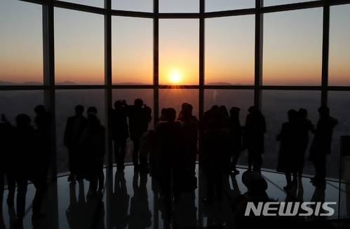 【서울=뉴시스】김진아 기자 = 2018 무술년 새해가 밝은 1일 오전 서울 송파구 롯데월드타워를 찾은 시민들이 일출을 맞이하고 있다. 2018.01.01.   bluesoda@newsis.com