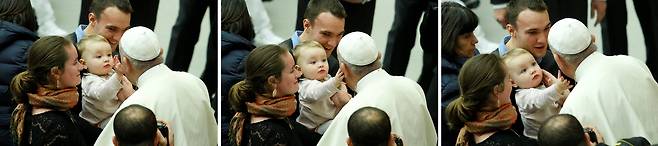 프란치스코 교황이 3일(현지시간) 바티칸 바오로 6세 알현실에서 열린 새해 첫 수요 일반알현에서 부모와 같이 온 어린아이가 자신의 볼을 어루만지자 같이 쓰다듬어 주고 있다.[로이터=연합뉴스]