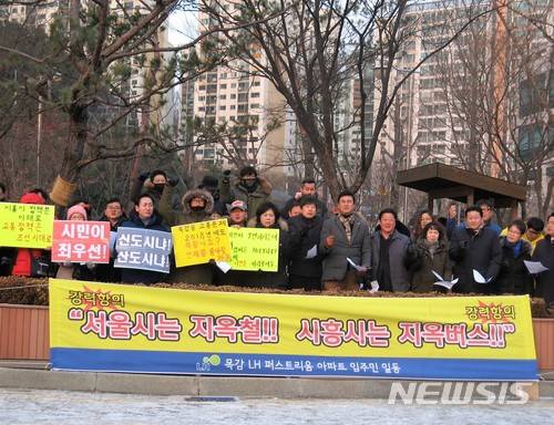 【시흥=뉴시스】이종일 기자 = 경기 시흥시 배곧신도시총연합회, 목감지구입주자대표회의 총연합회, 은계지구예비입주자대표회의 총연합회 등 3개 단체 회원들이 9일 시흥시청 정문 앞에서 집회를 열고 "버스 노선 개편으로 지옥버스 해결하라"고 촉구하고 있다. 2018.01.09.  lji22356@newsis.com