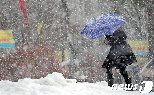 오후에도 전북지역에 눈이 내리다 그치다를 반복하고 있는 9일 전북 전주시 노송광장에서 한 시민이 우산으로 눈을 피하며 걸어가고 있다.2018.1.9/뉴스1 © News1 문요한 기자