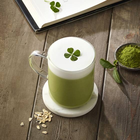 네잎 클로버가 올려진 스타벅스 코리아의 오트 그린티 라테.