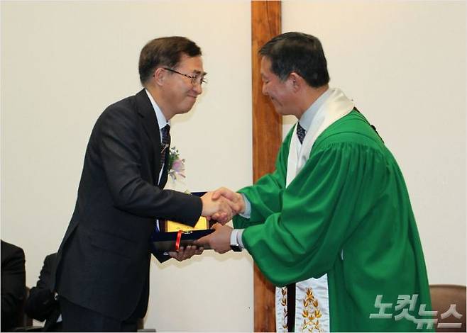 서울 새문안교회 7대 담임목사로 부임한 이상학 목사(왼쪽)가 위임패를 전달받고 있다.