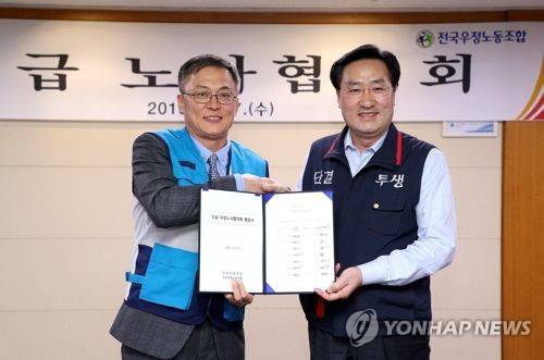 우정노사협의회 협정서 체결 (서울=연합뉴스) 우정사업본부와 전국우정노동조합은 17일 광화문우체국에서 노사협의회를 열고 집배원 주 5일근무 실시를 위한 협정서를 체결했다. 강성주 우정사업본부장(왼쪽)과 김명환 위원장이 협정서를 들고 악수를 하고 있다. 2018.1.17 [우정사업본부 제공]