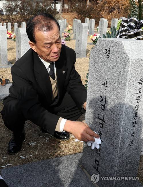 아들 묘비 닦는 아버지 (대전=연합뉴스) 이재림 기자 = 19일 대전 유성구 국립대전현충원 경찰관 묘역에서 김남훈 경사 부친 김권찬 씨가 손수건을 벗어 묘비를 닦고 있다.