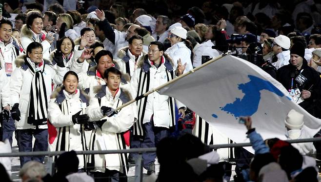 2006년 열린 이탈리아 토리노 동계올림픽 개회식 때 한반도기를 앞세워 공동입장하는 모습. 남측 이보라, 북측 한정인이 기수였다. 2018.1.9 연합뉴스