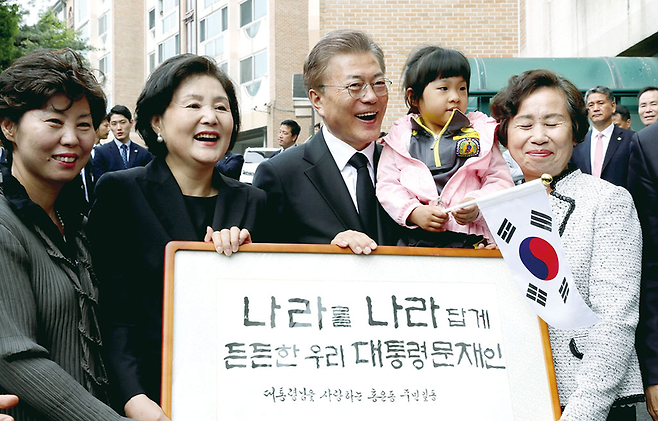문재인 대통령과 부인 김정숙 여사가 대통령 당선 다음 날인 지난해 5월10일 오전 홍은동 자택을 나서며 주민들의 환대를 받고 있다. © 사진=연합뉴스