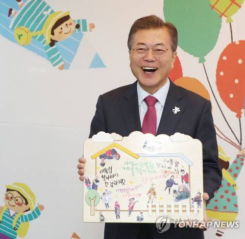 문 대통령, '66번째 생일' 어린이들의 손글씨 선물받고 함박웃음 (서울=연합뉴스) 김주형 기자 = 문재인 대통령이 24일 오전 보육정책과 관련한 현장 방문으로 서울 도봉구 한그루 어린이집을 방문해 어린이들과 마술공연 관람을 마친 뒤 어린이들의 손글씨가 담긴 선물을 받고  즐거운 표정을 하고있다.      오늘은 문 대통령의 66번째 생일이다.     kjhpress@yna.co.kr