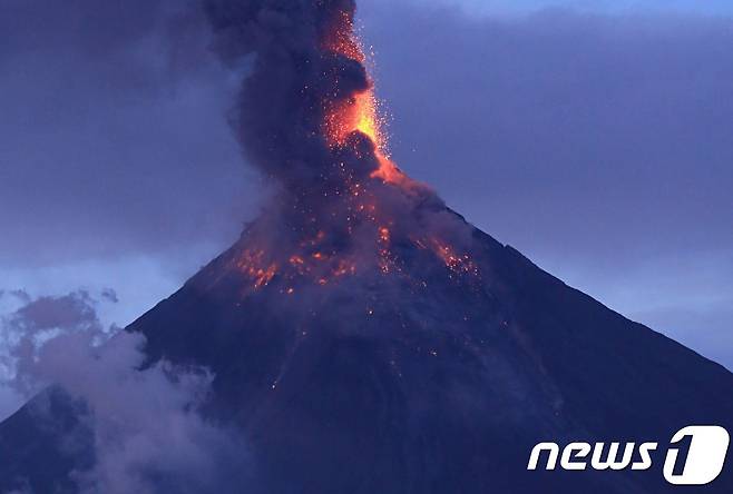 23일(현지시간) 필리핀 알바이 주 다라가에 있는 마욘화산에서 시뻘건 용암과 허산재 기둥이 솟아오르는 모습이 보이고 있다. © AFP=뉴스1 © News1