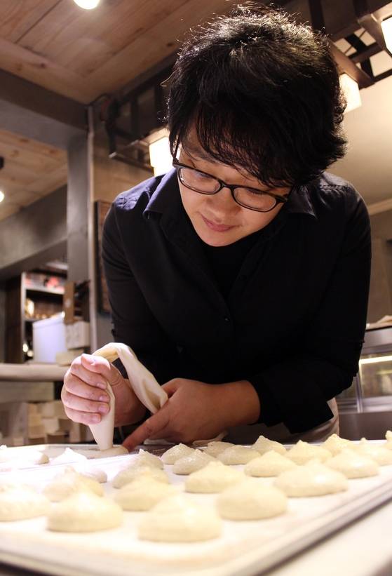 고영주 카카오봄 대표가 제품을 만들려고 짤주머니로 녹인 화이트 초콜릿을 틀에 짜고 있다. 그는 벨기에 PIVA호텔학교에서 수제 초콜릿·아이스크림을 정통으로 공부한 한국 쇼콜라티에 1세대의 쌍벽으로 꼽힌다.