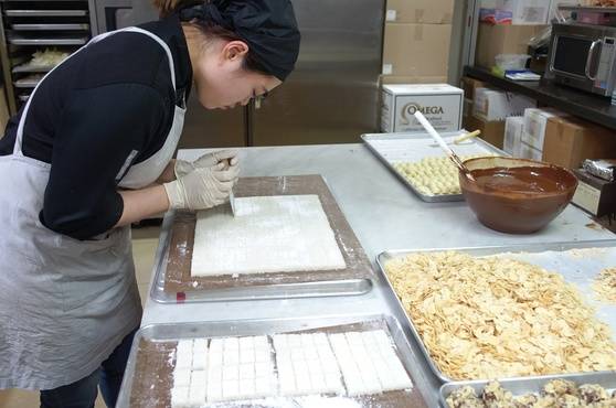 코코넛 트뤼플 초콜릿을 만들 때 속으로 넣을 떡 같은 코코넛 반죽을 카카오봄 직원이 일정한 모양으로 자르고 있다.