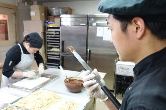 크림 트뤼플 초콜릿을 만들려고 녹인 다크 초콜릿 온도를 살피는 카카오봄 직원.