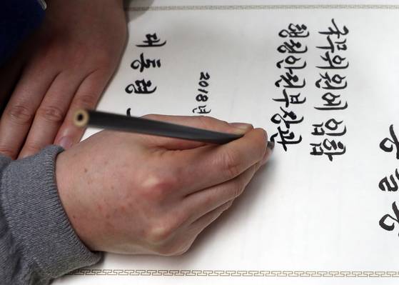 김이중 사무관이 붓에 벼루에 있는 먹물을 적신 뒤 임명장을 작성하고 있다. [최정동 기자]