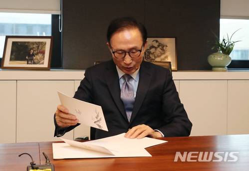 【서울=뉴시스】김진아 기자 =  이명박 전 대통령이 31일 오후 서울 강남구 사무실을 찾은 한병도 청와대 정무수석으로부터 평창 동계올림픽 초청장을 받은 뒤 확인하고 있다. 2018.01.31. photo@newsis.com