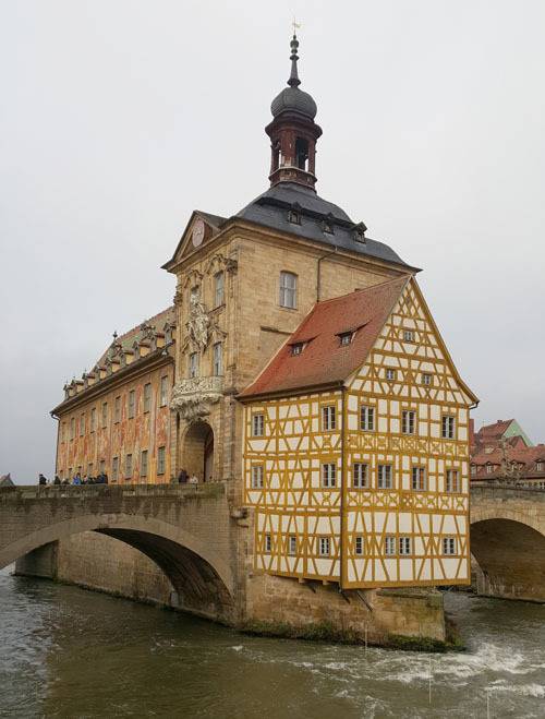 지난해 12월 5일 밤베르크의 옛 시청사 주변을 관광객들이 둘러보고 있다. 이 건물은 14세기 당시 레크니츠강을 경계로 영역 다툼을 벌이던 주교와 시민들이 시청사 위치를 놓고 대립하다 결국 중간지대인 강 위의 다리 중앙에 세워졌다고 한다.