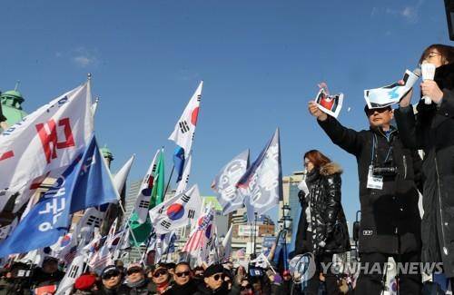한반도기·인공기 불 태우는 태극기집회 (서울=연합뉴스) 하사헌 기자 = 3일 오후 서울역 광장에서 열린 대한애국당의 '평양올림픽' 반대 태극기집회에서 참가자들이 한반도기와 인공기 종이를 불태우고 있다. 2018.2.3  toadboy@yna.co.kr  (끝)