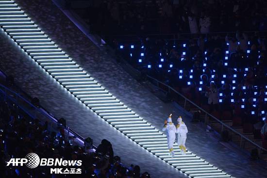 박종아와 정수연이 김연아에게 성화를 전하기 위해 성화대로 오르고 있다.