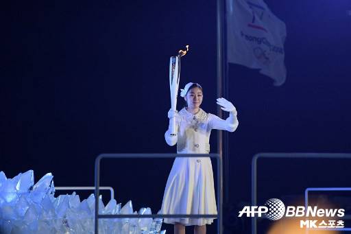 김연아가 모든 사람들의 시선 속에서 손을 흔들어 보이고 있다.