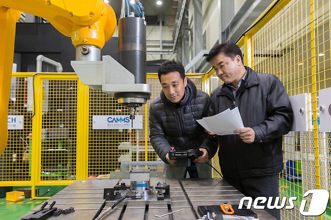 이석우 수석연구원(왼쪽)과 김태곤 선임연구원이 유연가공시스템에 들어가는 다관절 로봇을 활용해 탄소섬유복합재에 드릴링 가공을 시도하고 있다.