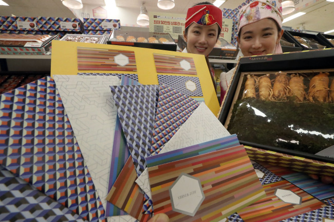 Models show envelopes designed for Saebaetdon, cash gifts exchanged among family members, as part of the Lunar New Year gift set sold at Emart in Seoul. (Yonhap)