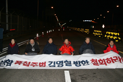 24일 오후 자유한국당 김무성 김영철방한저지투쟁위위원장, 김성태 원내대표(오른쪽 두번째부터) 등 한국당 의원들이 김영철 북한 노동당 대남 담당  부위원장 겸 통일전선부장의 방남 철회를 주장하며 경기 파주 통일대교 위에서 연좌농성하고 있다.  연합뉴스