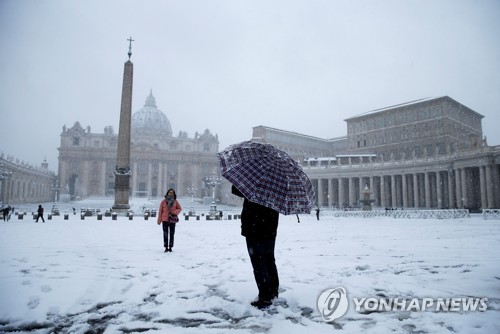 26일 눈 덮인 바티칸 성베드로광장에서 관광객들이 사진을 찍고 있다. [로이터=연합뉴스]