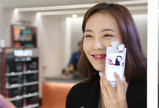 한 여성이 올리브영에서 측색기로 자신의 피부톤을 측정하고 있다. [사진 올리브영]