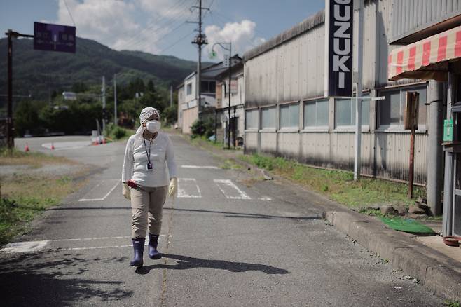 일본 후쿠시마현 나미에 지역의 쓰시마 거리에 살던 칸노 미즈에씨가 참사 이후 약 7년 만에 자신의 집을 둘러보고 있다. | 그린피스 제공