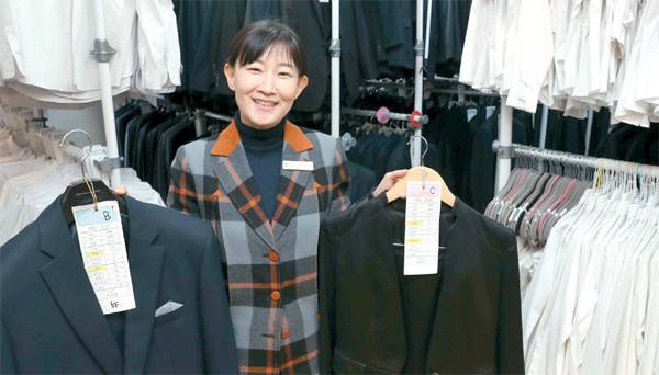 김소령 열린옷장 대표가 서울 광진구 사무실에서 꼼꼼하게 세부 사이즈가 적혀 있는 정장들을 취재진에게 보여주고 있다. [이충우 기자]
