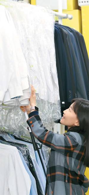 김소령 열린옷장 대표가 사무실 내 대여실에서 고객을 기다리고 있는 정장을 꼼꼼히 살펴보고 있다. 열린옷장이 시민과 기업 기부자에게 기증받은 정장은 남성복 1500벌, 여성복 1000벌 등 2500벌에 이른다. 열린옷장은 옷 기증 스토리와 응원 메시지를 대여자에게 문자로 보내 격려한다. [이충우 기자]