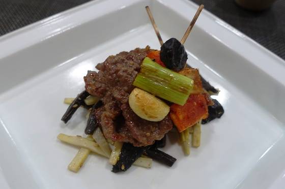 마늘·대파와 고추장 양념한 더덕 꼬치구이를 얹어 완성한 불고기와 능이죽순채.