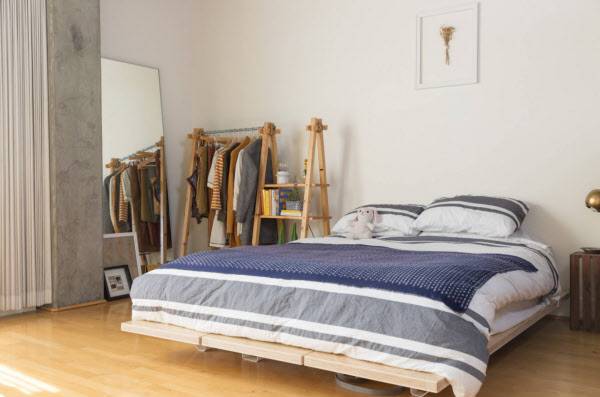 화이트 벽면, 우드컬러 바닥, 진한 블루톤의 침구. /laurenedith.com