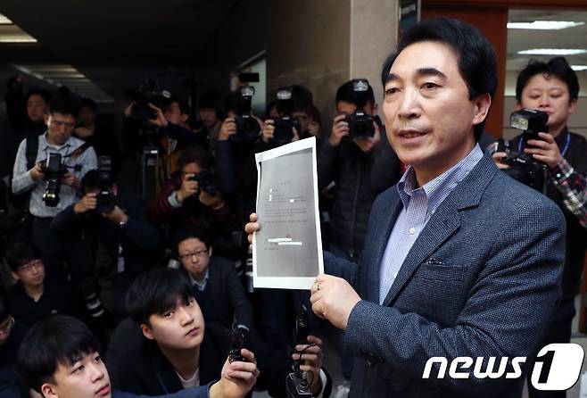 충남도지사 선거에 나선 박수현 더불어민주당 예비후보가 11일 오전 서울 여의도 국회 정론관에서 여성당직자 특혜공천의혹과 불륜 의혹에 대한 해명 기자회견에서 김영미 공주시의회 의원 전 남편 진술서를 들어보이고 있다. 2018.3.11/뉴스1 © News1 박정호 기자