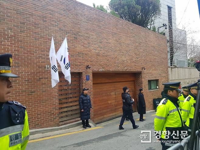 14일 서울 논현동 이명박 전 대통령 자택 앞에 경찰 병력이 경비를 서고 있다. 자택에는 태극기가 걸려 있다. /김지혜 기자