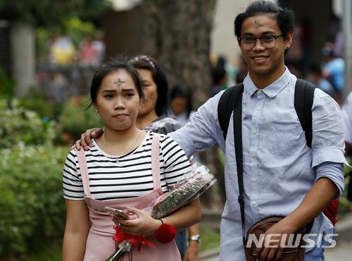 【파라냐케=AP/뉴시스】필리핀 의회가 이혼을 허용하는 법안을 추진하고 있다고 CNN 필리핀이 22일 보도했다. 하원 인구가족관계위원회가 전날 이혼법인 ‘무조건적 이혼 제도화 법(An act instituting absolute divorce in the Philippines)’의 제정안을 .만장일치로 가결했다. 커플이 밸런타인데이인 지난 14일 메트로마닐라 외곽 파라냐케에 있는 한 성당에서 나오고 있다. 2018.02.22