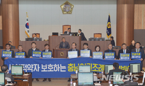【예산=뉴시스】유효상 기자 = 2일 열린 충남도의회 제301회 임시회 2차 본회의에서 김종문 의원이 충남도민 인권증진 조례 폐지안에 대한 반대 토론을 하고 있는 가운데 더불어민주당 소속 의원들이 시위를 벌이고 있다. 2018.02.02   yreporter@newsis.com