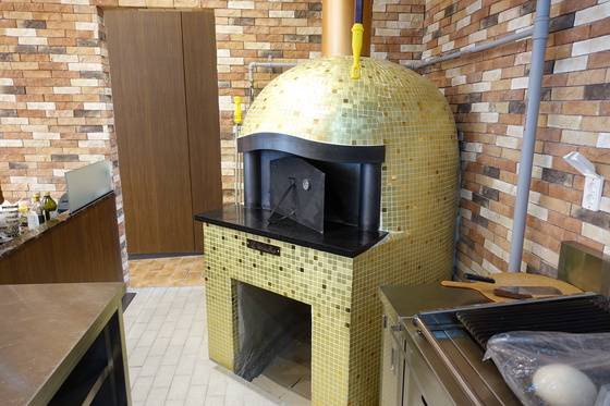 금빛 타일로 장식한 ‘R.ENA’ 레스토랑의 가스 화덕. 피자와 팬에서 1차 구운 스테이크를 굽는다.