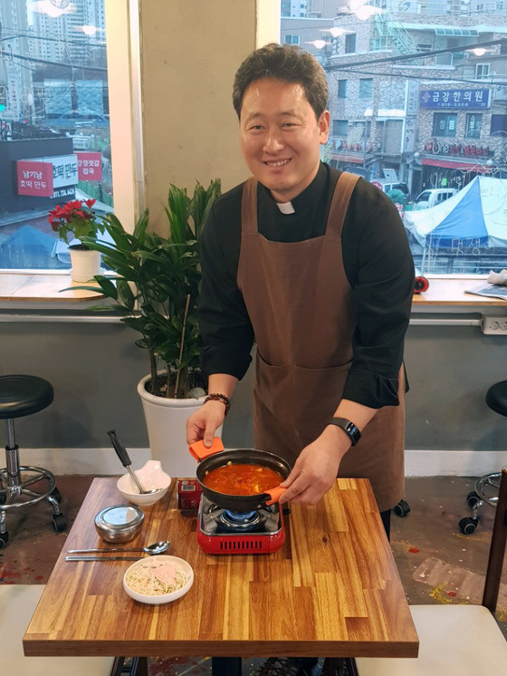 이문수 신부가 지난 21일 자신이 운영하는 청년식당 '문간'에서 김치찌개를 서빙하고 있다. 임선영 기자