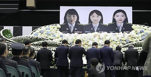 작별의 시간 (아산=연합뉴스) 양영석 기자 = 2일 오전 충남 아산 이순신체육관에서 열린 순직 소방공무원과 임용 예정 교육생의 합동 영결식을 찾은 가족들이 고인들과 마지막 작별인사를 하며 헌화하고 있다.  소방관과 소방관 임용 예정 교육생 등 3명은 지난 30일 43번 국도변에서 개 포획활동을 벌이던 중 25t 화물차가 추돌한 소방펌프카에 치여 숨졌다. 2018.4.2  youngs@yna.co.kr