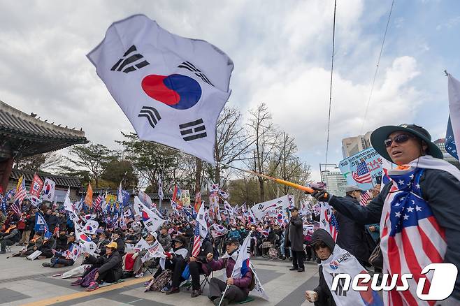 박근혜 전 대통령 지지자들이 7일 서울 덕수궁 대한문 앞에서 열린 태극기시민혁명운동본부 주최 태극기 혁명 국민대회에서 태극기와 성조기를 흔들며 박 전 대통령의 1심 선고 판결에 대해 규탄하고 있다. 2018.4.7/뉴스1 © News1 유승관 기자