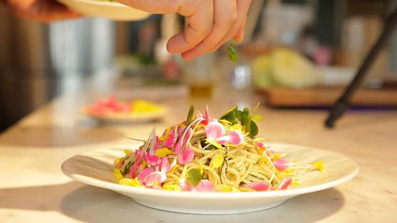 접시에 파스타를 올리고 꽃잎을 뿌린다.