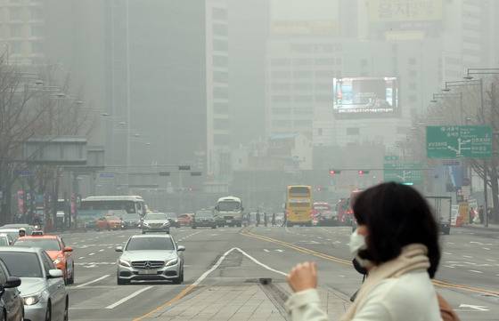 수도권 미세먼지 저감조치가 시행된 지난달 26일 서울 광화문광장에서 시민들이 마스크를 하고 출근하고 있다. 강정현 기자